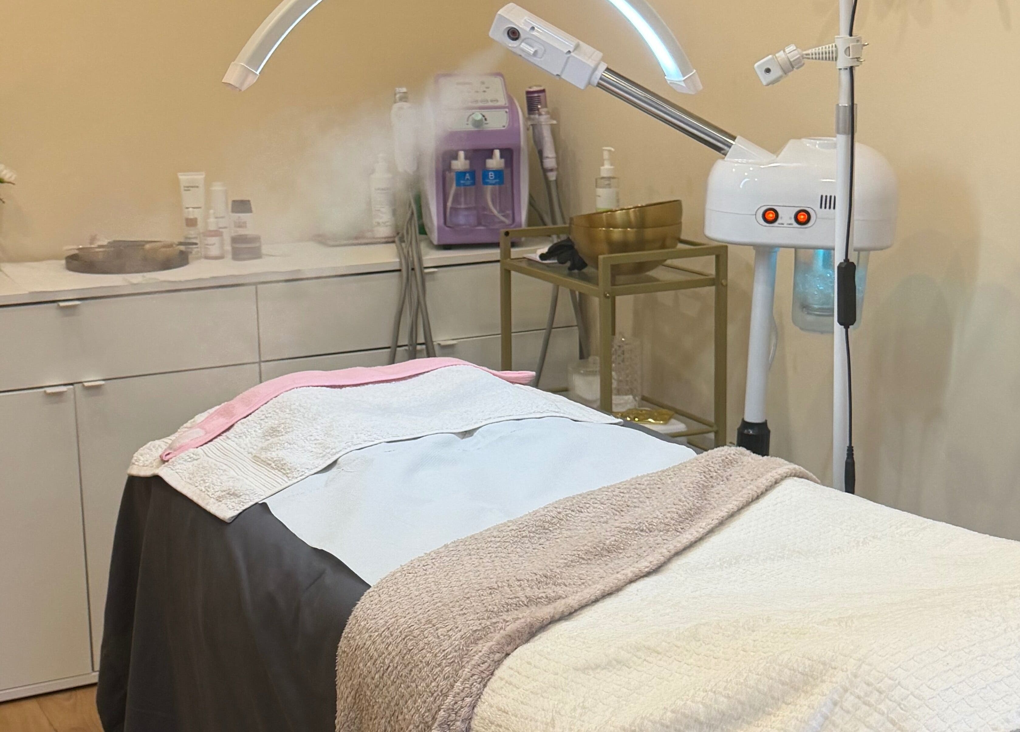 A serene treatment room at Zafirah Aesthetic Beauty, London, England, GB, with a massage table and equipment.