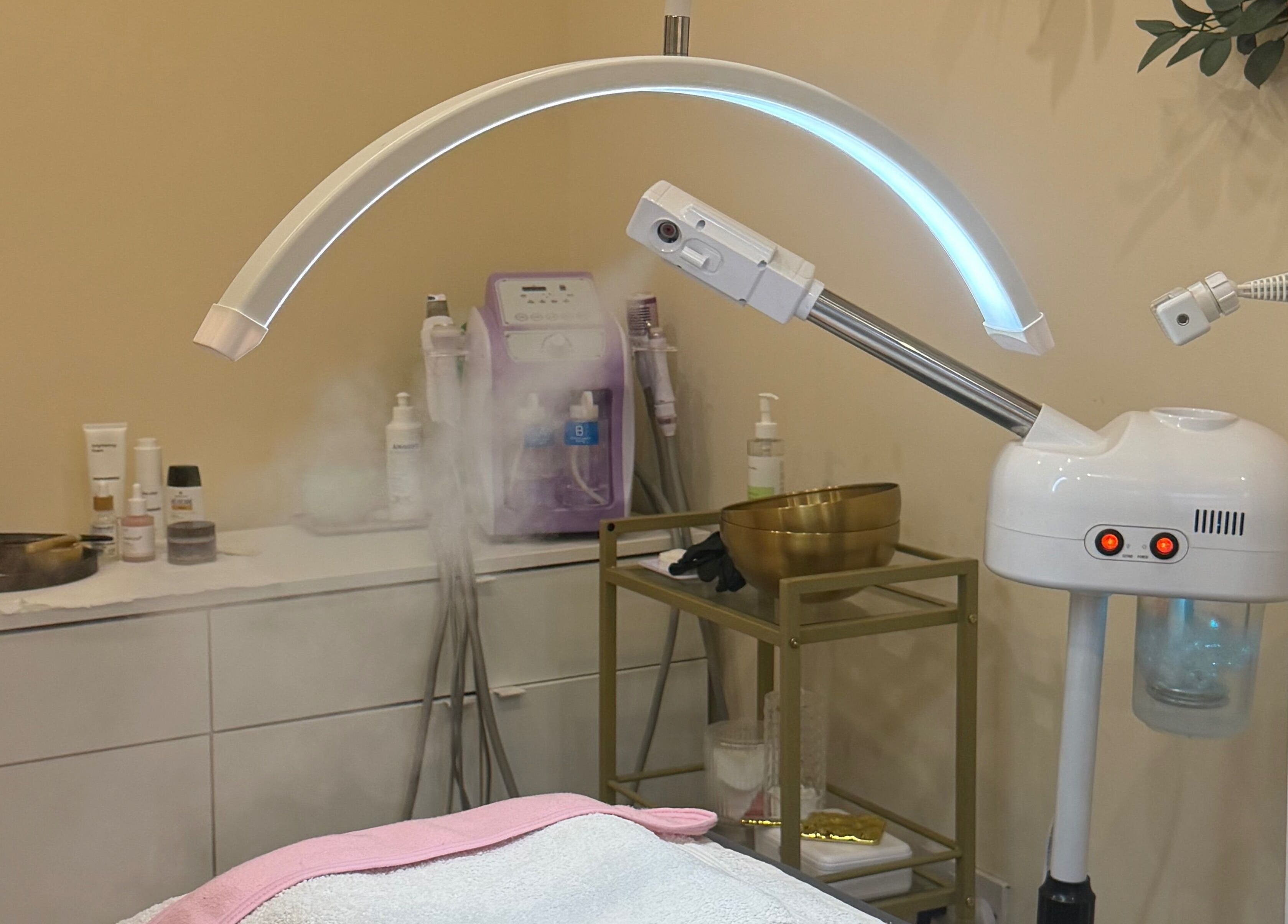 Spa treatment room at Zafirah Aesthetic Beauty in London, England, GB featuring facial steamer and skincare products.