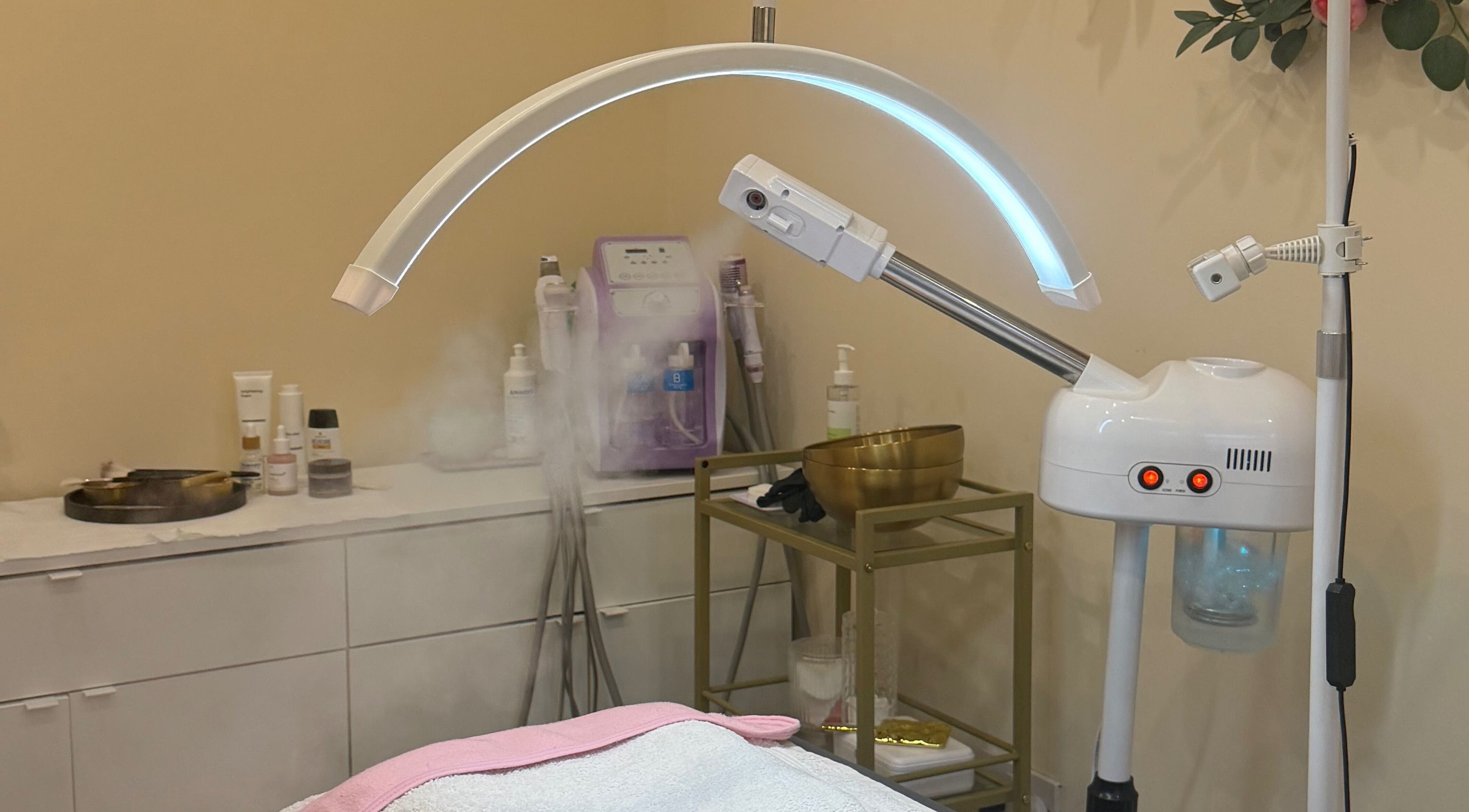 Spa treatment room at Zafirah Aesthetic Beauty in London, England, GB featuring facial steamer and skincare products.