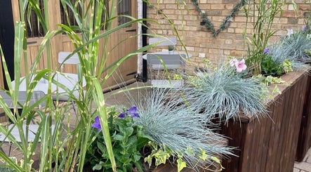 Charming garden seating at Skin by Anna, Biggleswade, England, GB with lush plants and a cozy atmosphere.