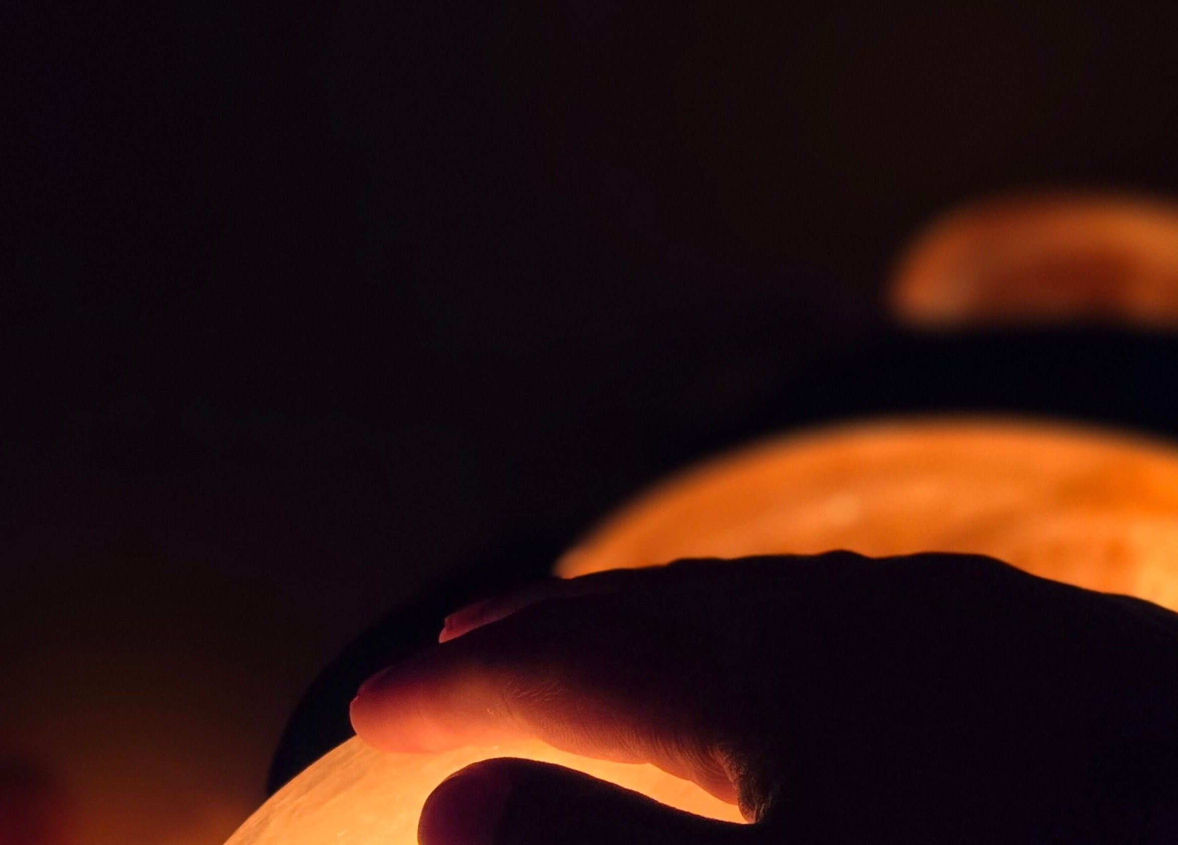 Hand touching warm salt lamp at Simply Salt Wellness & Salt Cave, Welland, Ontario, CA.