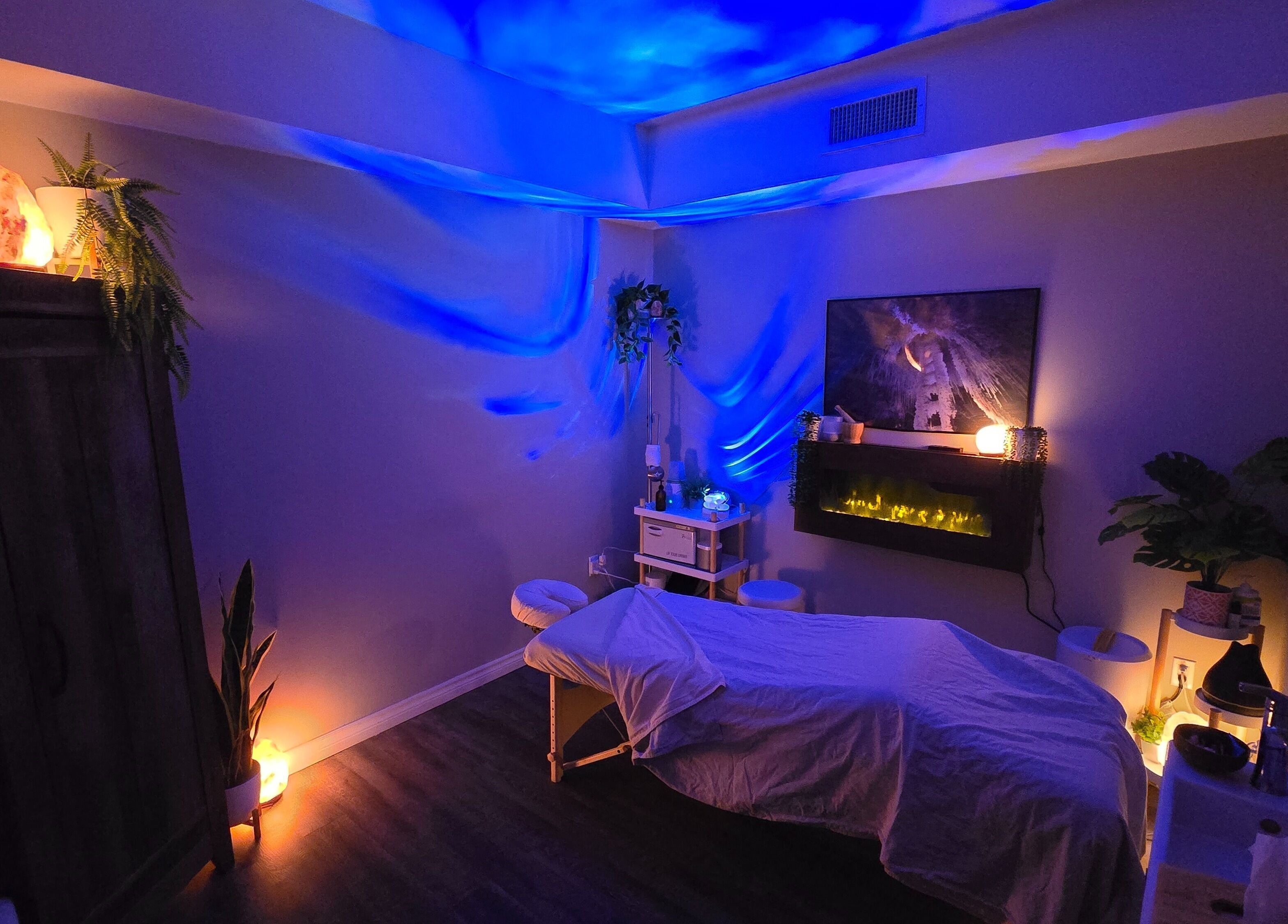 Peaceful massage room at Simply Salt Wellness & Salt Cave in Welland, Ontario, CA, glowing with calming blue lights.