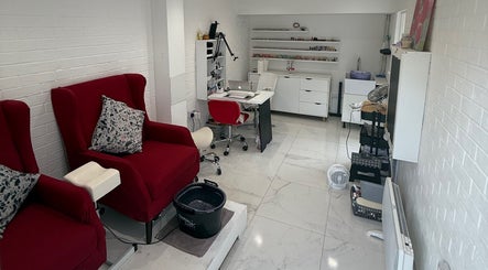 SENNUBIA beauty salon in London, England, GB with plush red chairs and a sleek workstation for treatments.