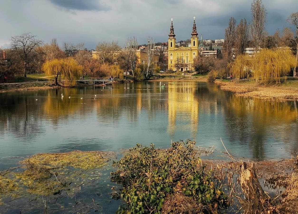Scenic lake view near Szluka Cecília frissítőmasszőr in Budapest, Magyar, HU with reflections of a church.