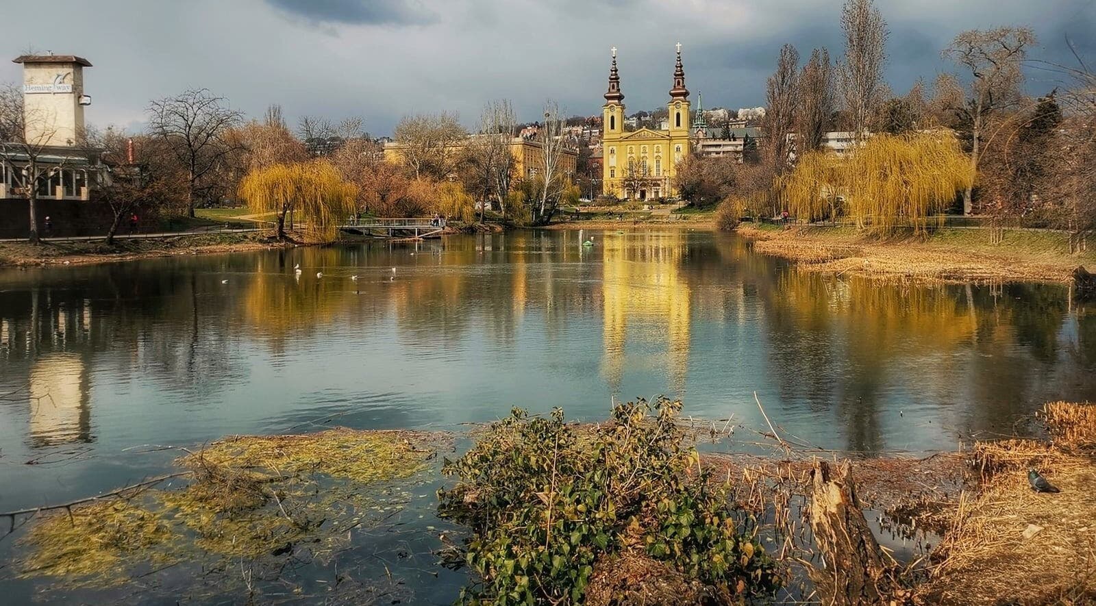 Scenic lake view near Szluka Cecília frissítőmasszőr in Budapest, Magyar, HU with reflections of a church.