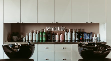 Xelia Hair & MediSpa inc, Moncton, NB: Array of haircare products on shelves above salon wash basin.