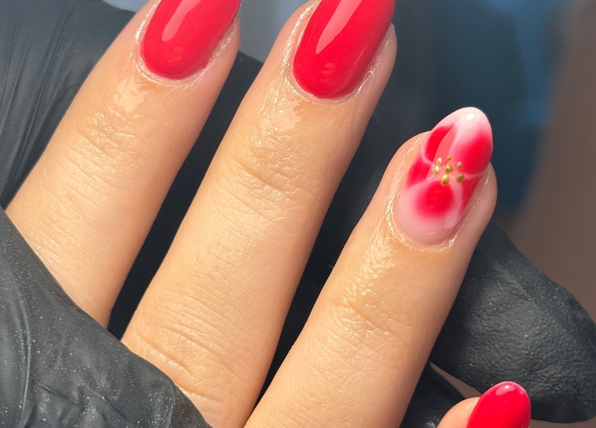 Red manicured nails with floral design at LGD nails, Fareham, England, GB.