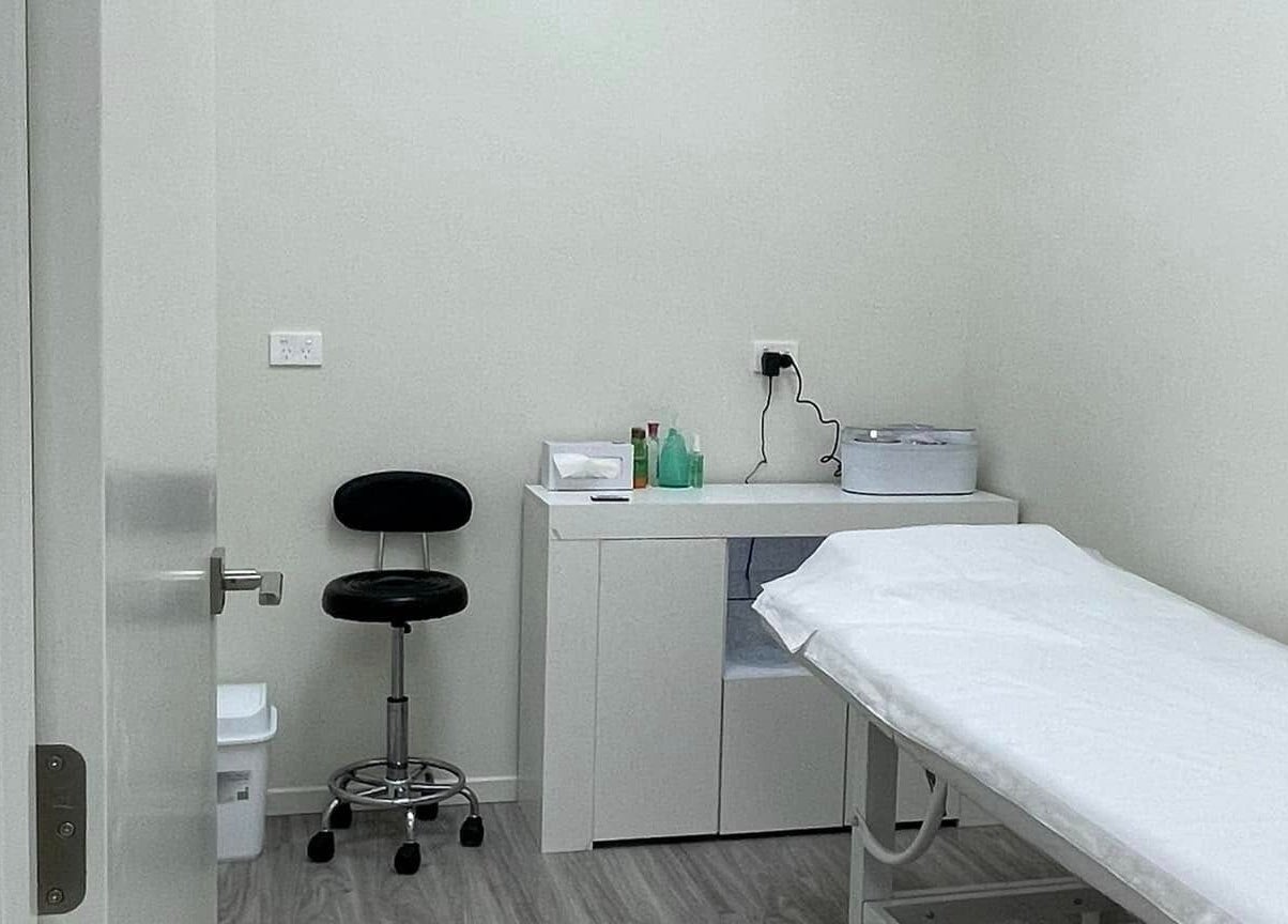 Relaxing treatment room at Enhance Beauty And Brows, Rolleston, Canterbury, NZ, with bed and equipment.