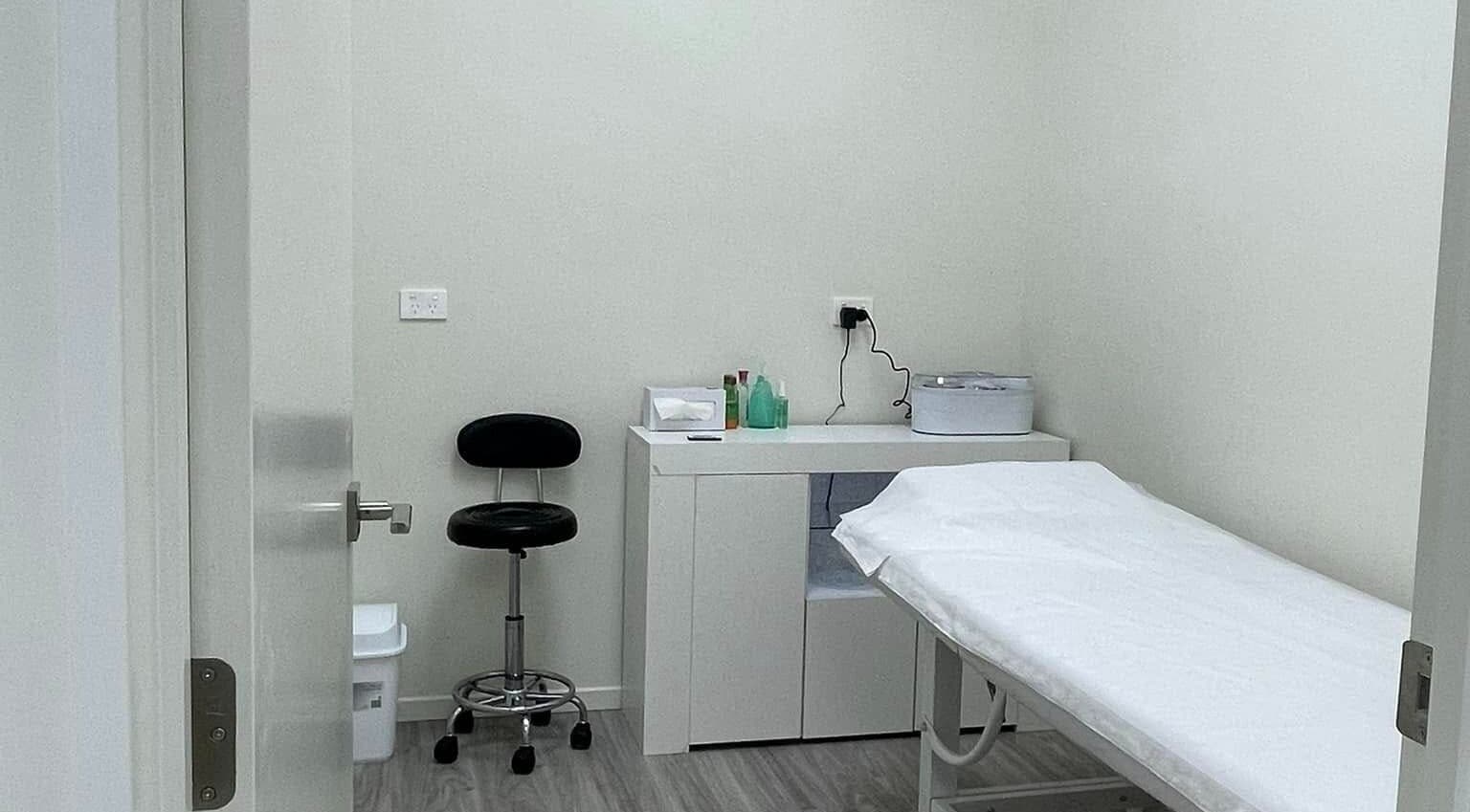 Relaxing treatment room at Enhance Beauty And Brows, Rolleston, Canterbury, NZ, with bed and equipment.