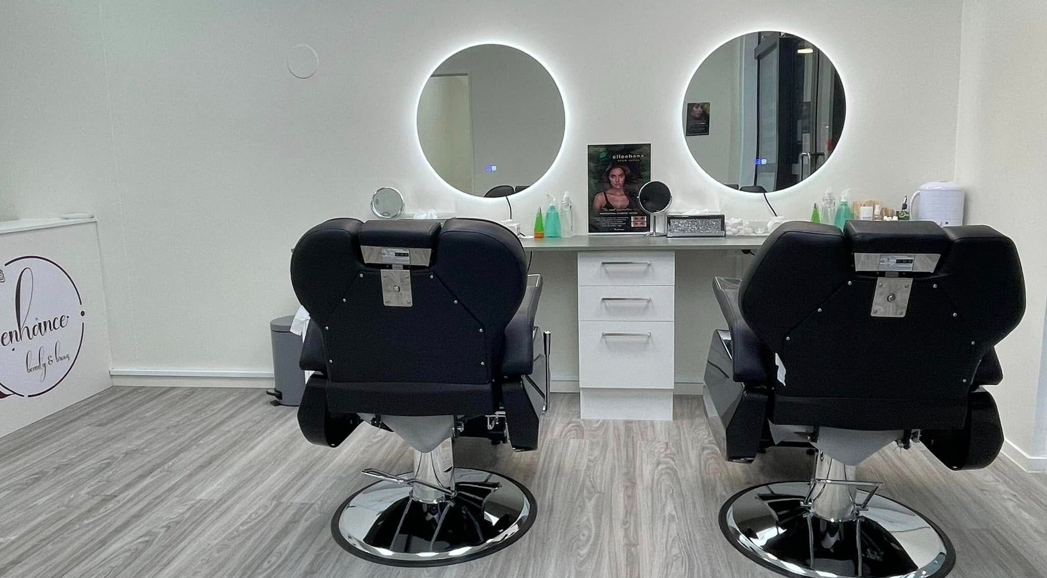 Modern salon interior at Enhance Beauty And Brows in Rolleston, Canterbury, NZ with two styling chairs.