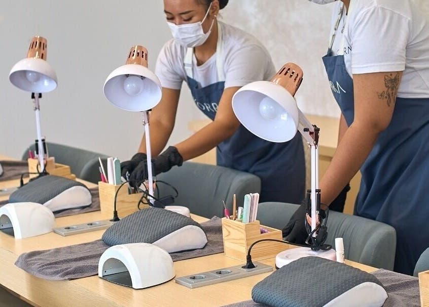 Staff at Korra Spa and Nails in Bali prepare manicure stations for clients.