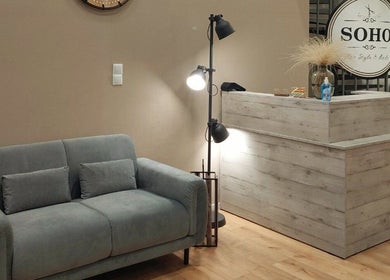Υποδοχή στο Soho Hair Style & Nails, Λάρισα, GR με μοντέρνο καναπέ και κομψό φωτιστικό.