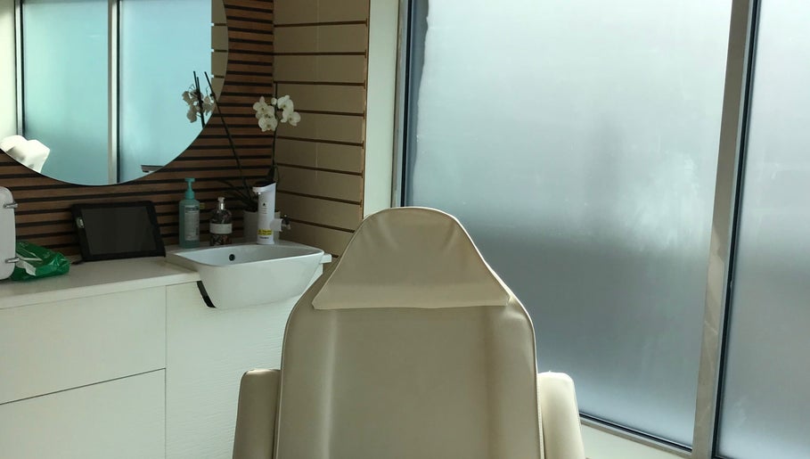 Elegant treatment room at HTR Aesthetics in Bristol, England, GB with a plush chair and modern decor.