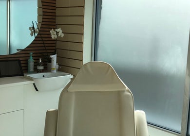 Elegant treatment room at HTR Aesthetics in Bristol, England, GB with a plush chair and modern decor.