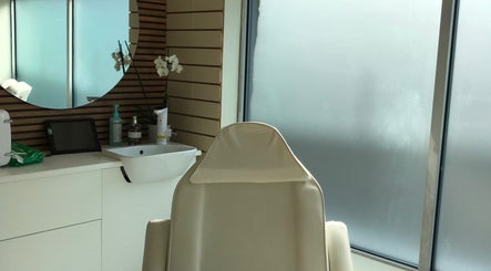 Elegant treatment room at HTR Aesthetics in Bristol, England, GB with a plush chair and modern decor.