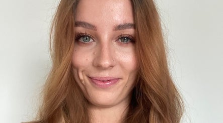 Smiling woman receiving beauty treatment at HTR Aesthetics, Bristol, England, GB.