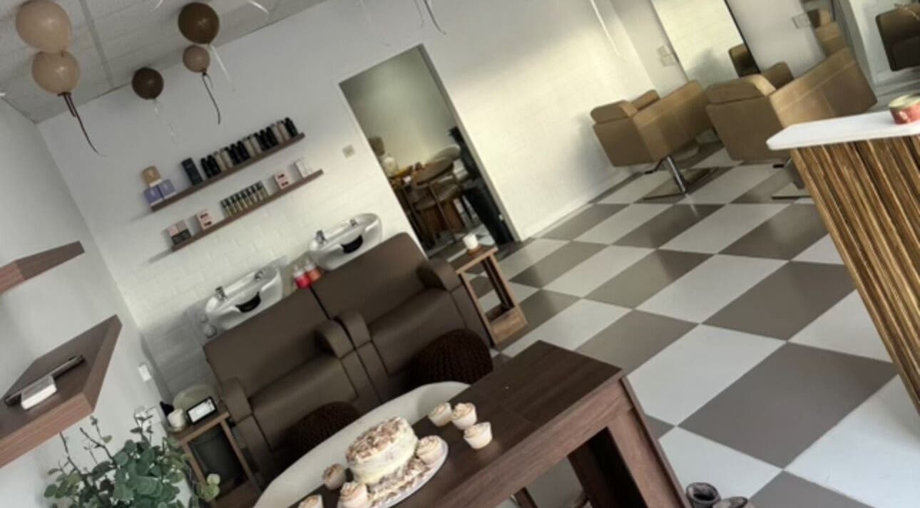Interior of Fawn Studios, a chic beauty venue in Hyde, England. Modern salon chairs and decor on checkered floor.