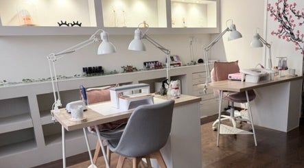 Espacio de uñas en Paramio Studio, Valladolid, Castilla Y León, ES, con mesas iluminadas y sillas elegantes.