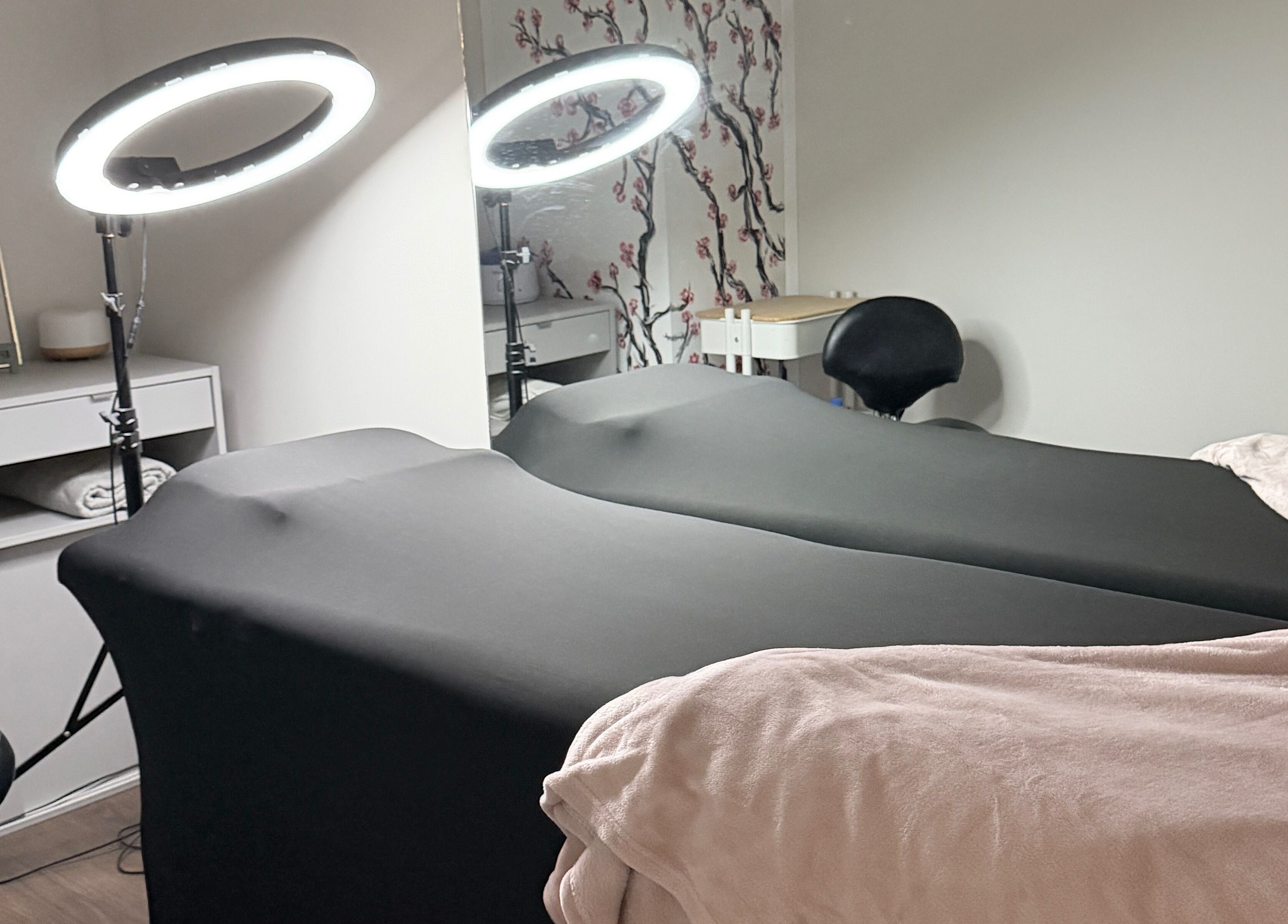 Sala de tratamiento en Paramio Studio en Valladolid, Castilla Y León, ES, con camillas y luces LED circulares.