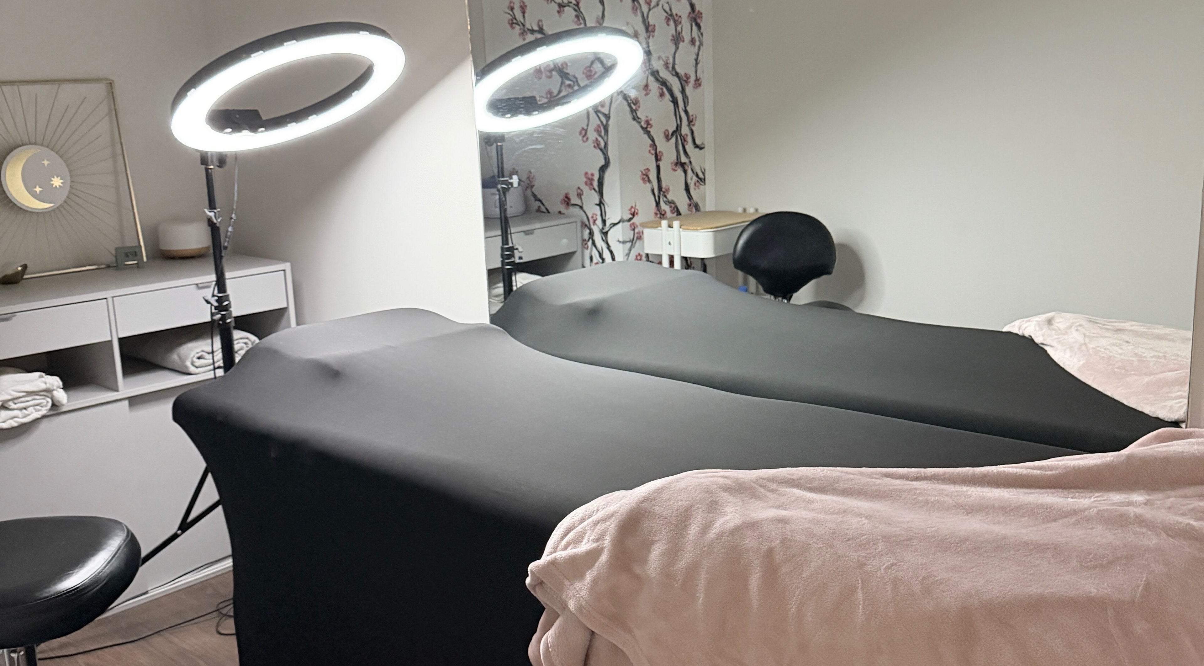 Sala de tratamiento en Paramio Studio en Valladolid, Castilla Y León, ES, con camillas y luces LED circulares.