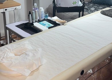 Relaxing treatment room setup at Deluxe Wax Boutique, London, England, GB featuring a comfortable massage bed.