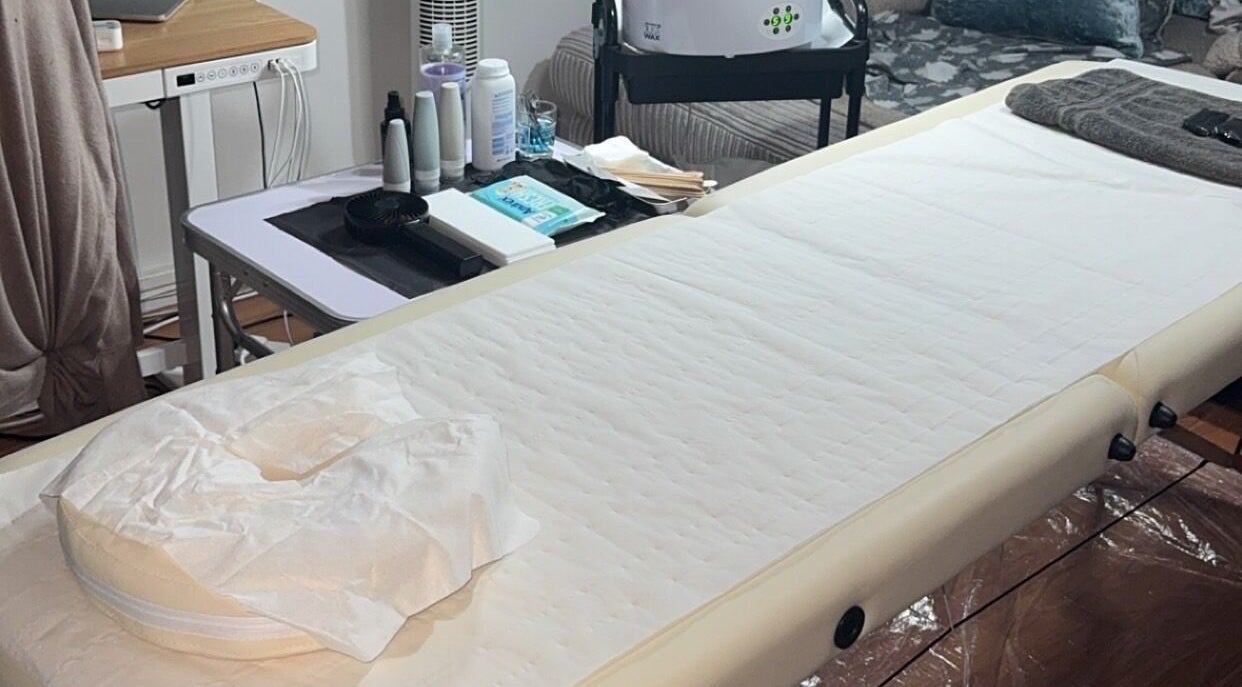 Relaxing treatment room setup at Deluxe Wax Boutique, London, England, GB featuring a comfortable massage bed.