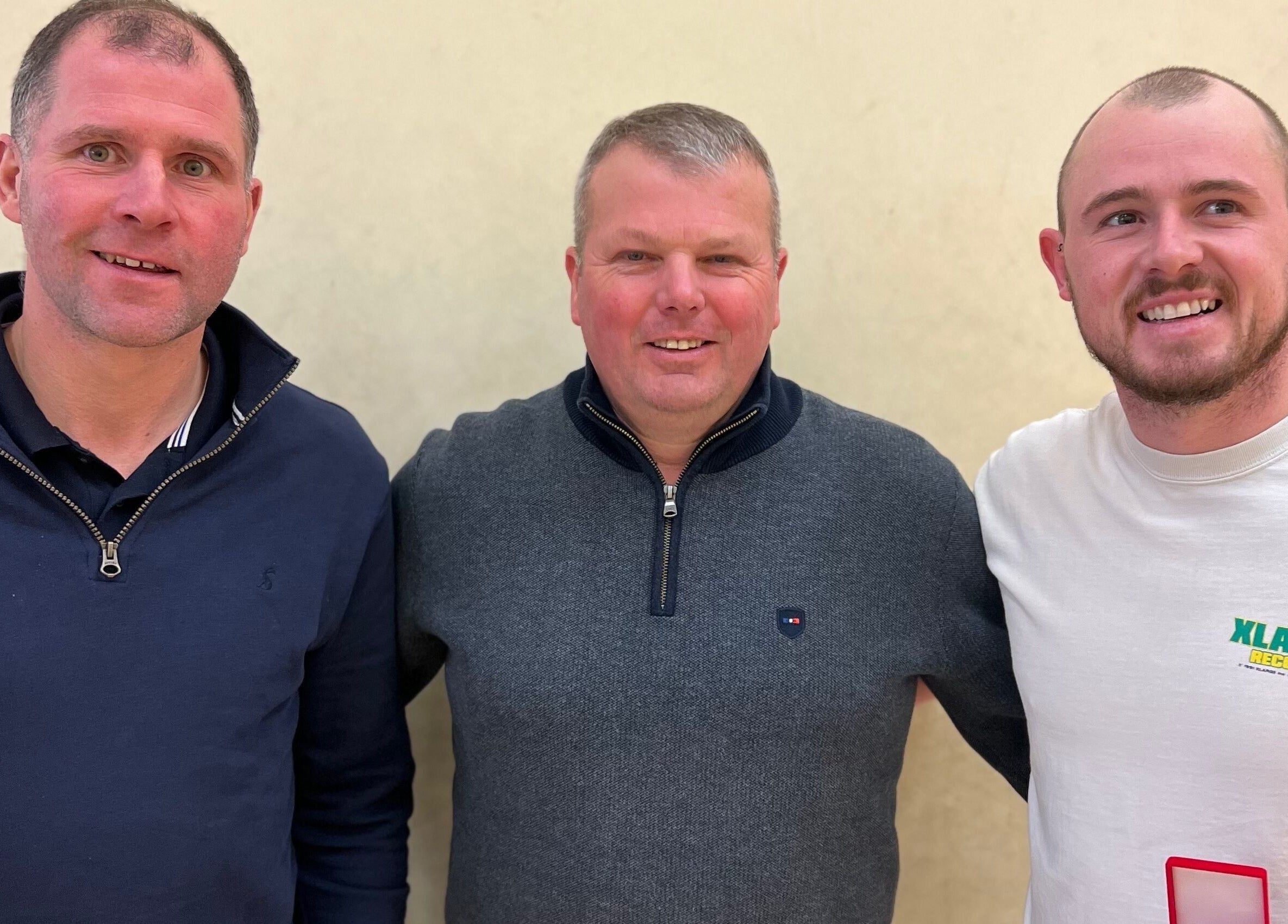 Three individuals smiling together at Saval Handball, Newry, Northern Ireland, GB.