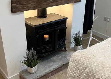 Elegant fireplace at The Glow Collective in Lichfield, England, GB with plants and plush decor.
