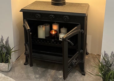 Warm candlelit stove setting at The Glow Collective, Lichfield, England, GB.