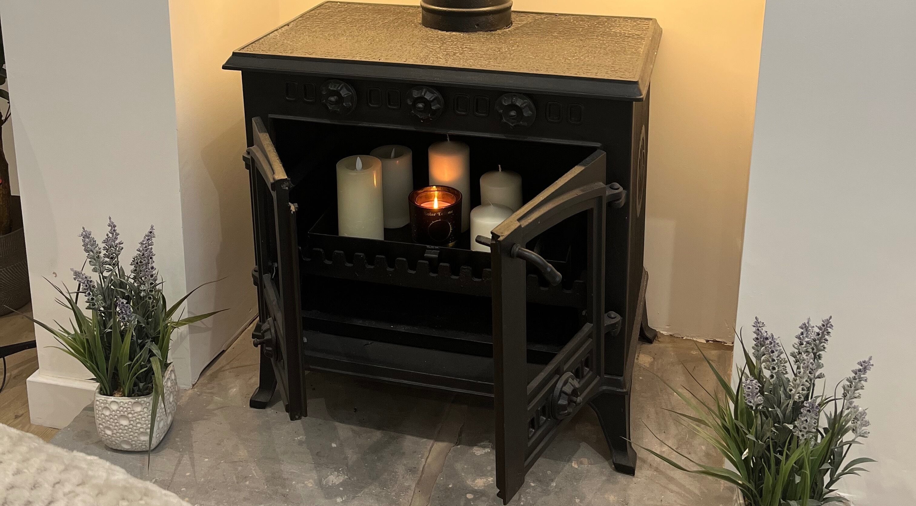 Elegant candle display in a fireplace setting at The Glow Collective, Lichfield, England, GB.