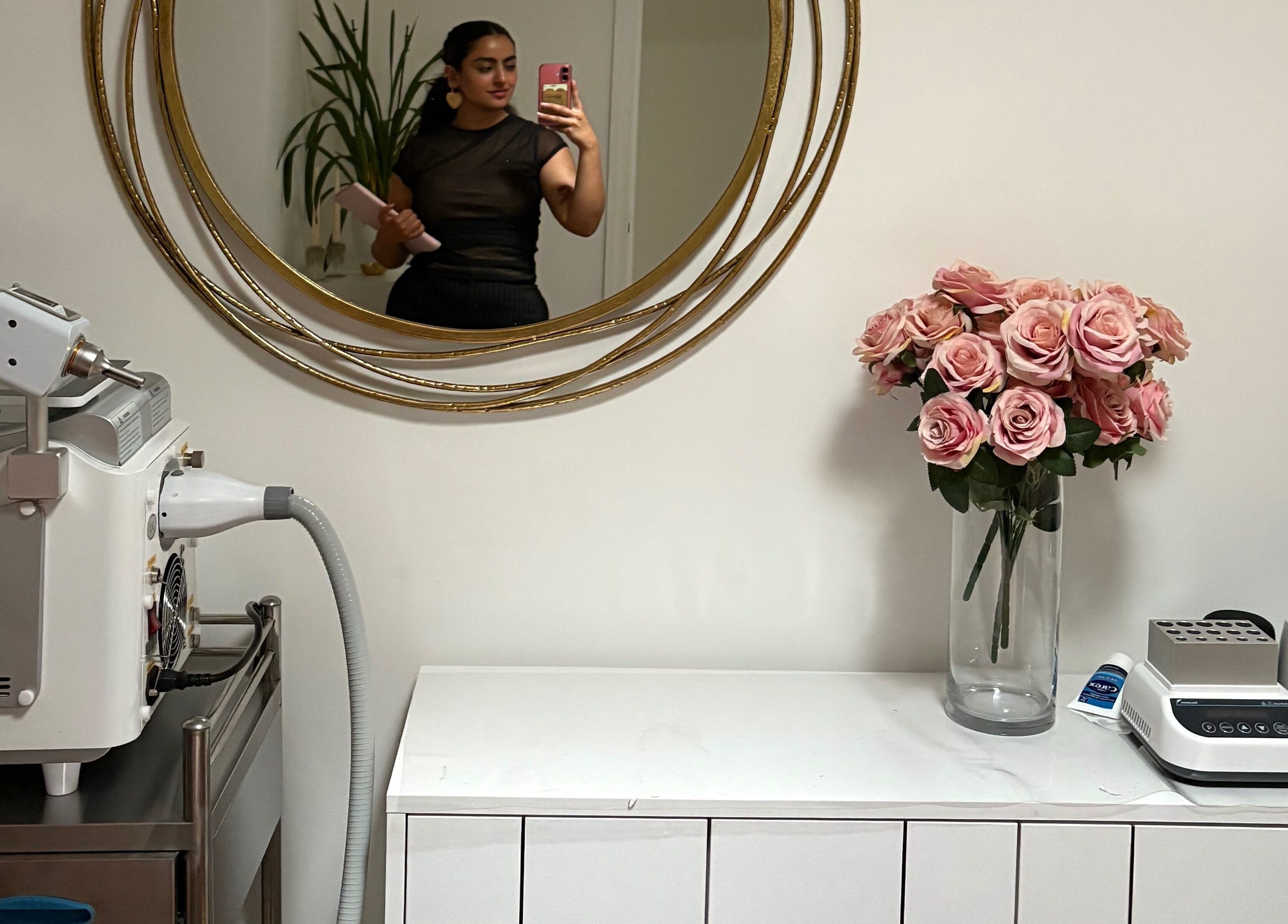 Elegant setup at Ethereal Aesthetics, London, England, featuring a mirror, roses, and beauty devices.