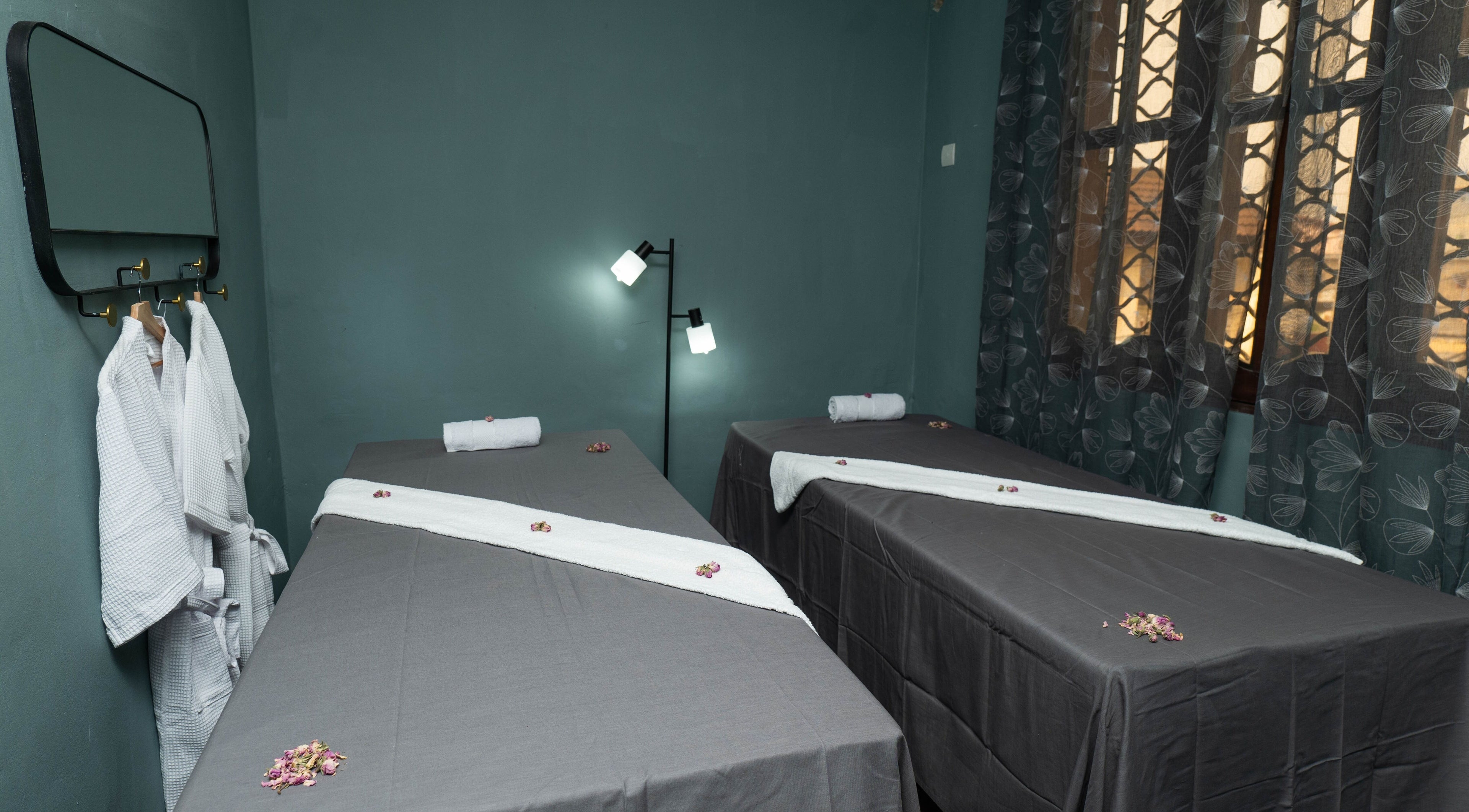 Salle de massage à Nature Divine Beauty & Spa, Douala, Région Du Littoral, CM, avec lits et peignoirs.