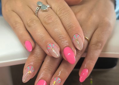 Nail art vibrant à Simonæil's, Senonches, Centre-val De Loire, FR. Ongles roses et motifs artistiques scintillants.