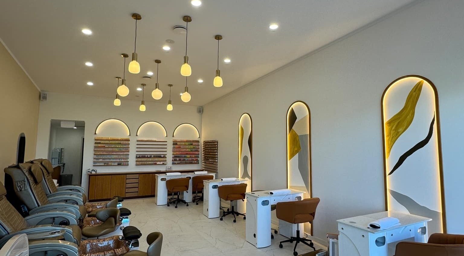 Interior of Sunshine Nails & Beauty in Auckland, NZ, showcasing chic nail stations and plush seating.