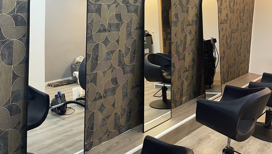 Área elegante do salão twoBeauty em Forte Da Casa, Lisboa, PT com poltronas pretas e espelhos modernos.