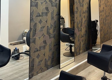 Área elegante do salão twoBeauty em Forte Da Casa, Lisboa, PT com poltronas pretas e espelhos modernos.