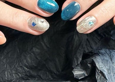 Vibrant gemstone nail art at CutieNailStudio, Glendora, California, US. Stunning blue and metallic accents.