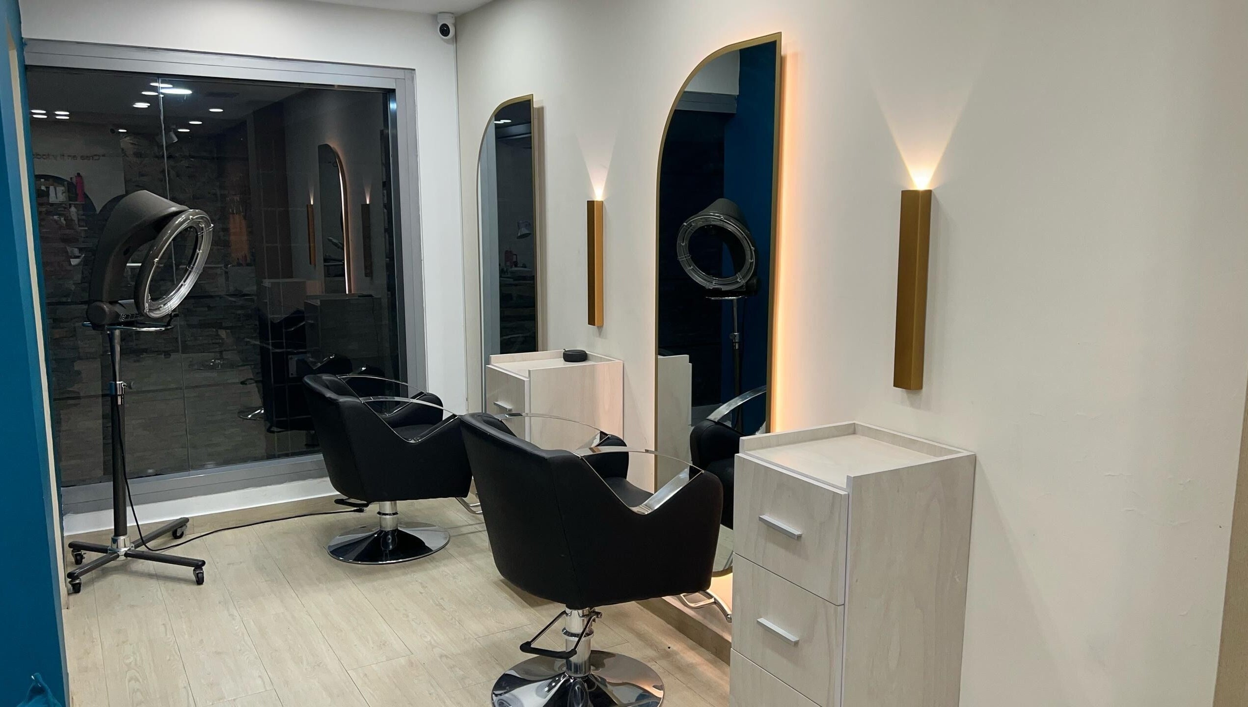 Interiores modernos de Piel Morena Salon en Naguanagua, Carabobo, VE. Sillas negras y espejos iluminados.