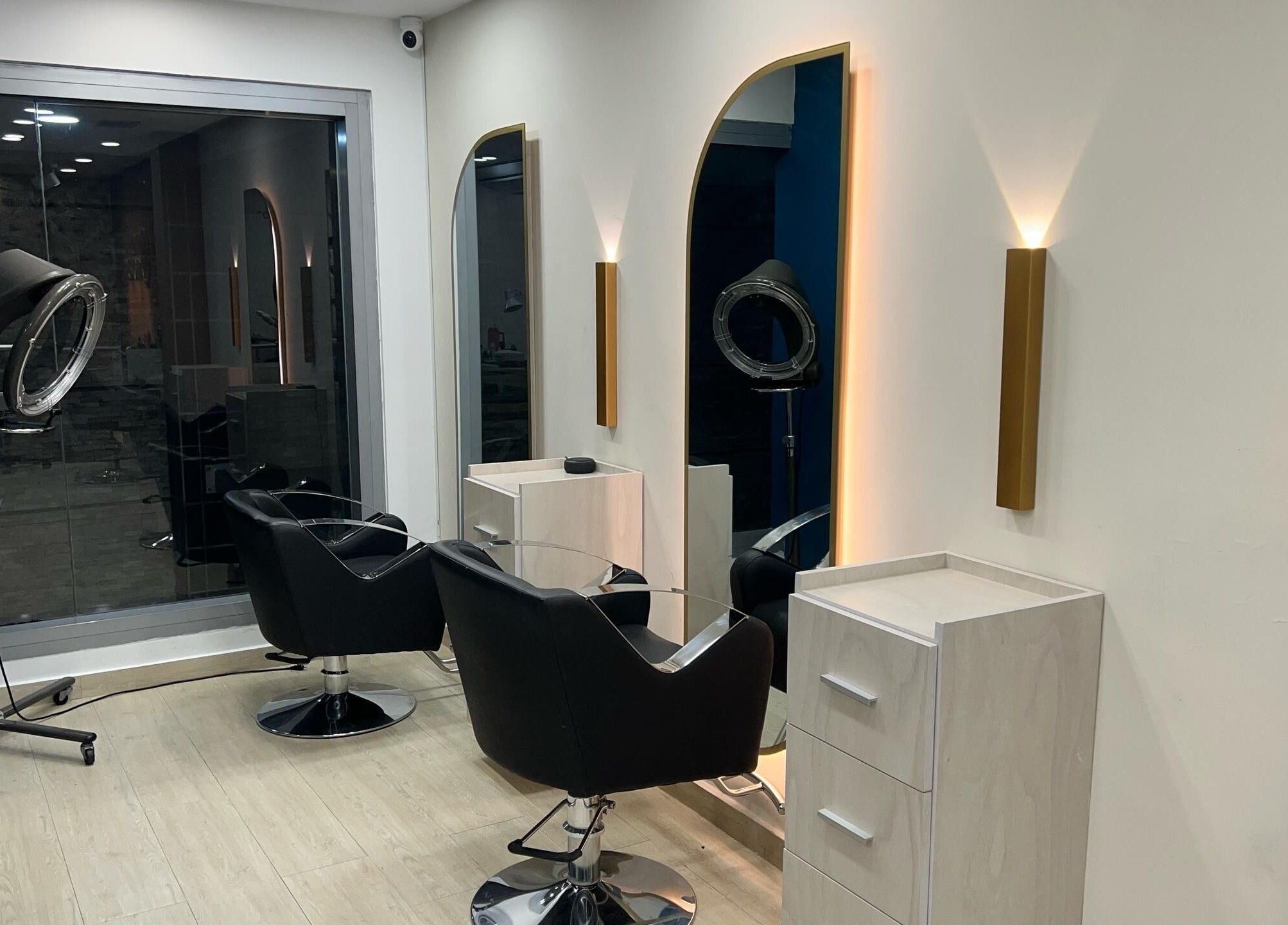Interiores modernos de Piel Morena Salon en Naguanagua, Carabobo, VE. Sillas negras y espejos iluminados.
