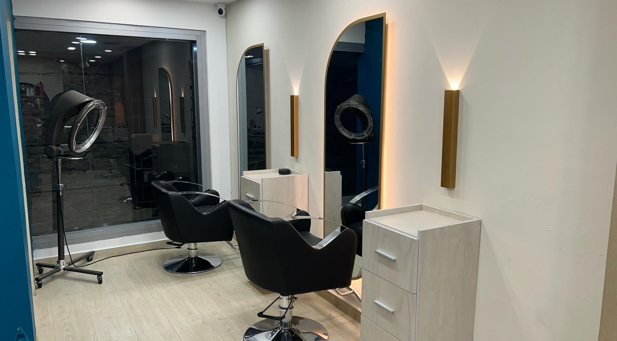 Interiores modernos de Piel Morena Salon en Naguanagua, Carabobo, VE. Sillas negras y espejos iluminados.