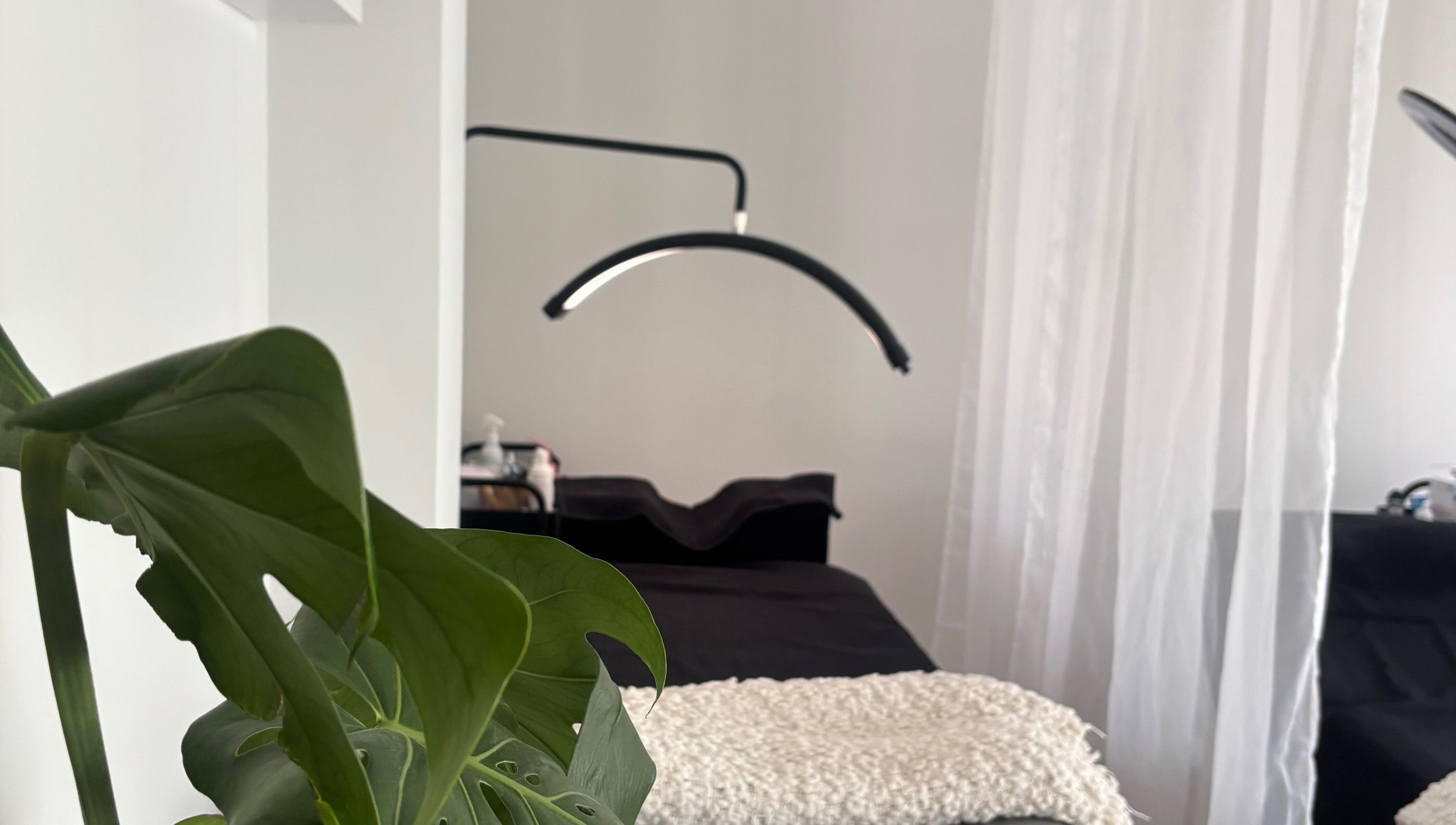 Tranquil treatment room at Brow Bliss in Mandurah, Western Australia, AU, featuring sleek decor and lush plants.