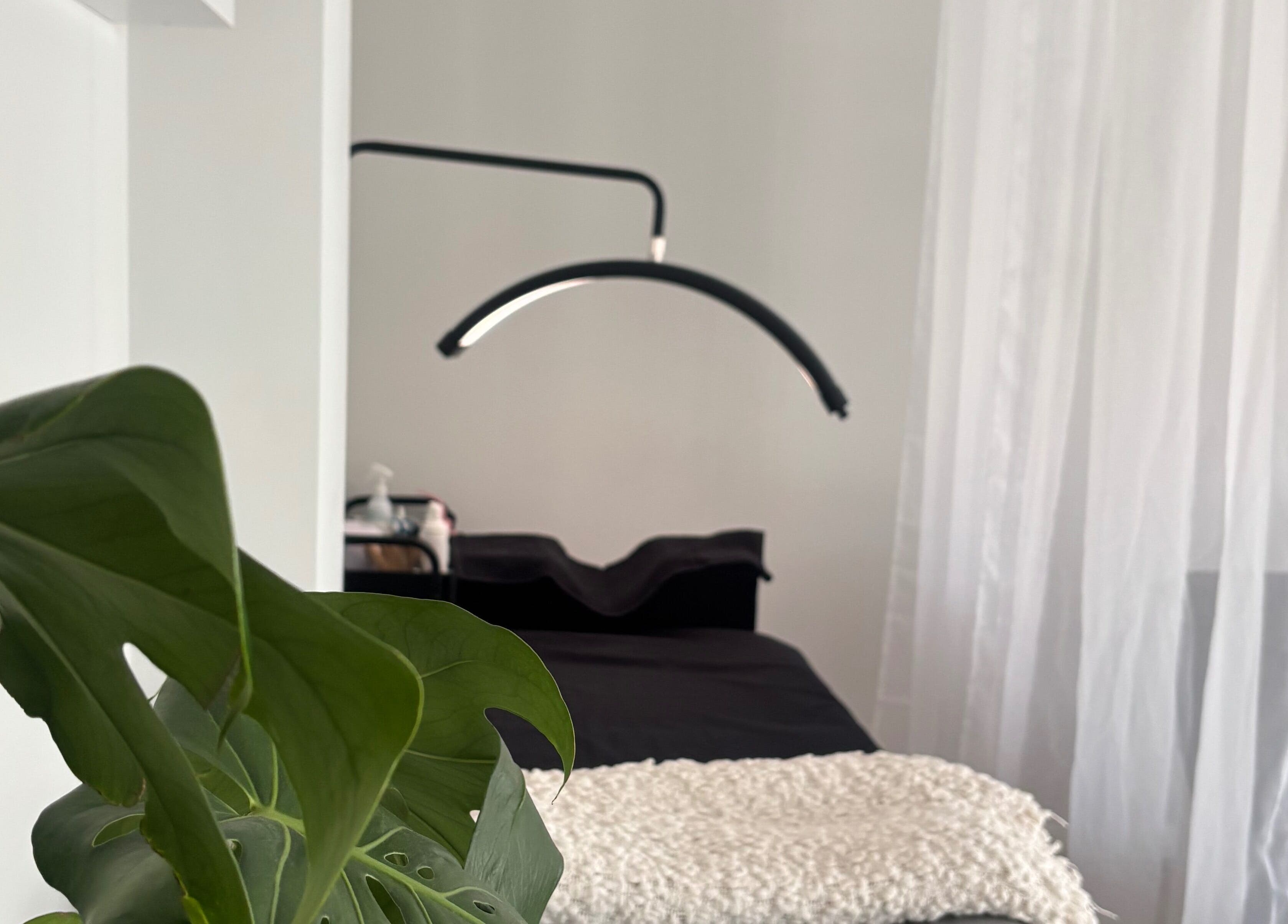 Tranquil treatment room at Brow Bliss in Mandurah, Western Australia, AU, featuring sleek decor and lush plants.
