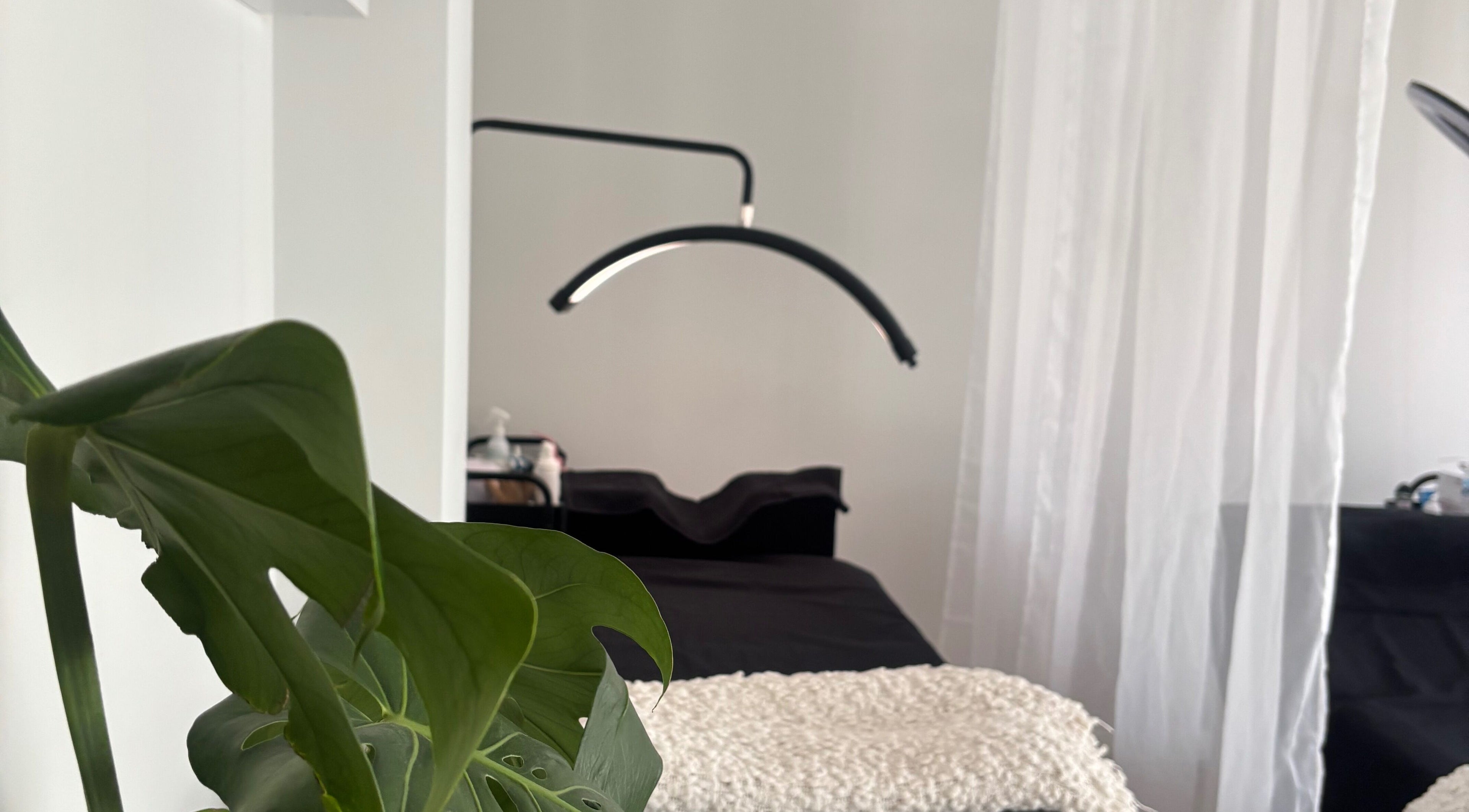 Tranquil treatment room at Brow Bliss in Mandurah, Western Australia, AU, featuring sleek decor and lush plants.