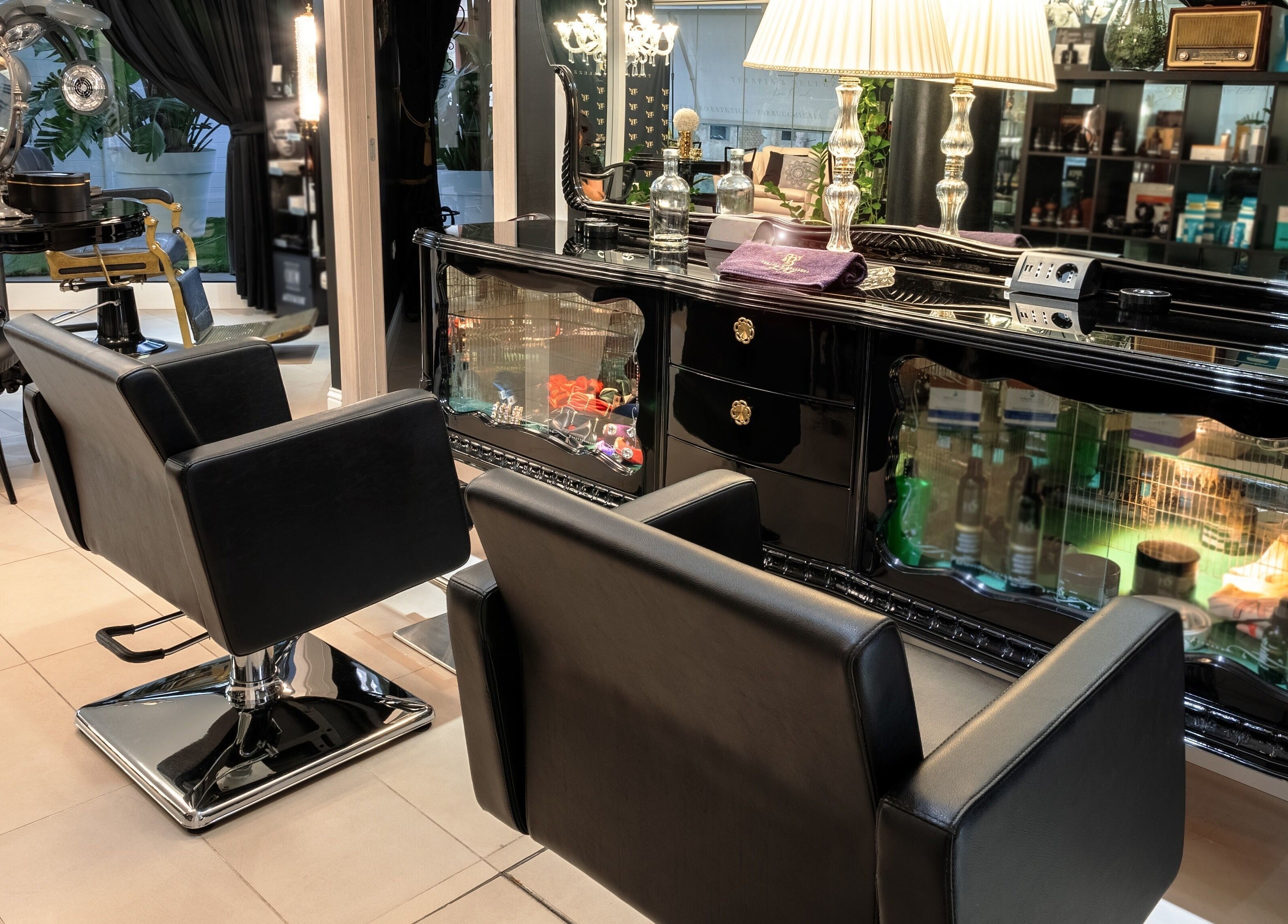 Lussuoso interno di Terapia & Bellezza di Sara Cauli, Cagliari, con sedie nere e decorazioni eleganti.
