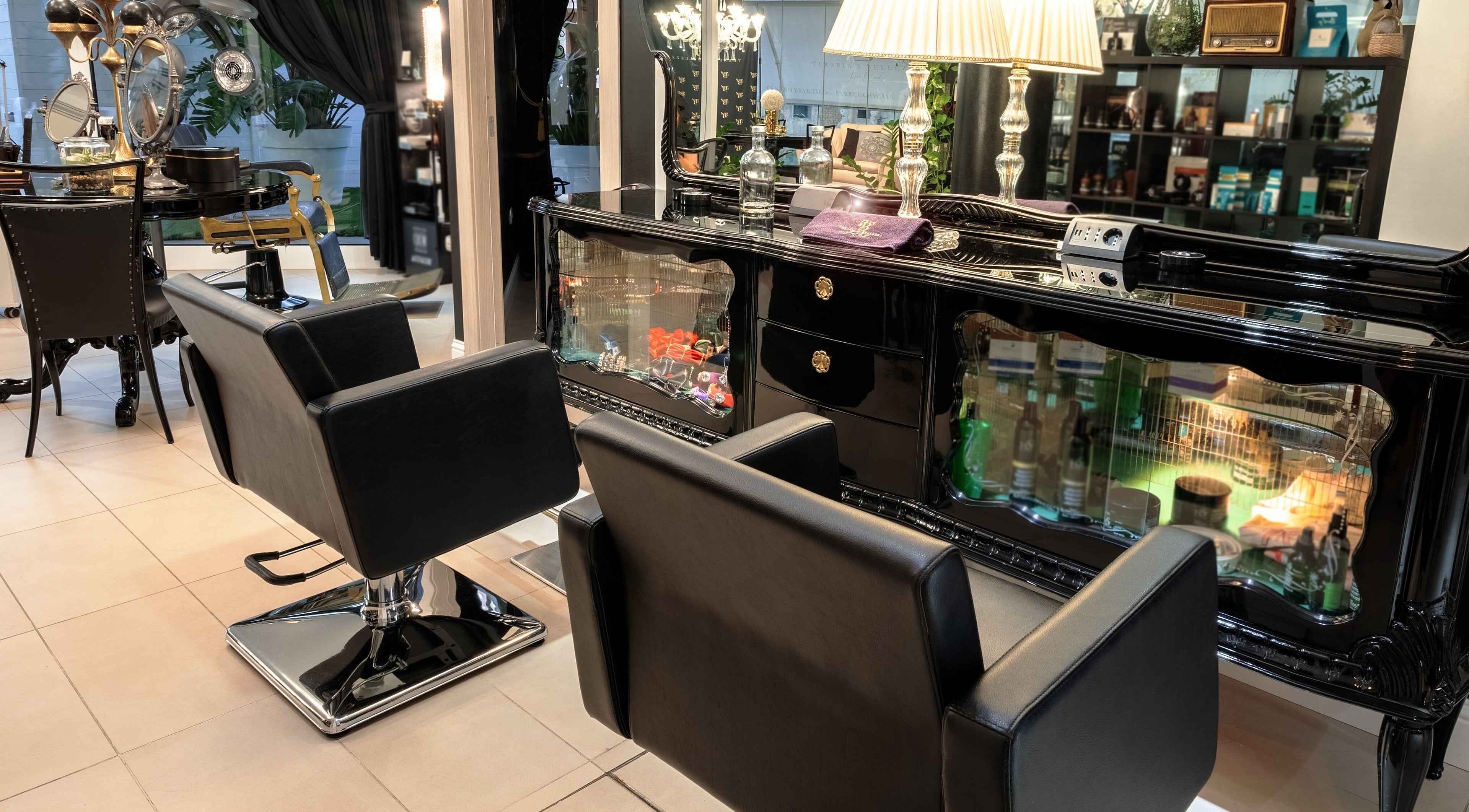 Lussuoso interno di Terapia & Bellezza di Sara Cauli, Cagliari, con sedie nere e decorazioni eleganti.
