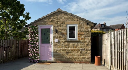 The Pink Beauty Room's quaint exterior with pink door, located in Huddersfield, England, GB.