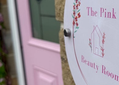 Elegant sign outside The Pink Beauty Room in Huddersfield, England, GB, showcasing a welcoming pink door.