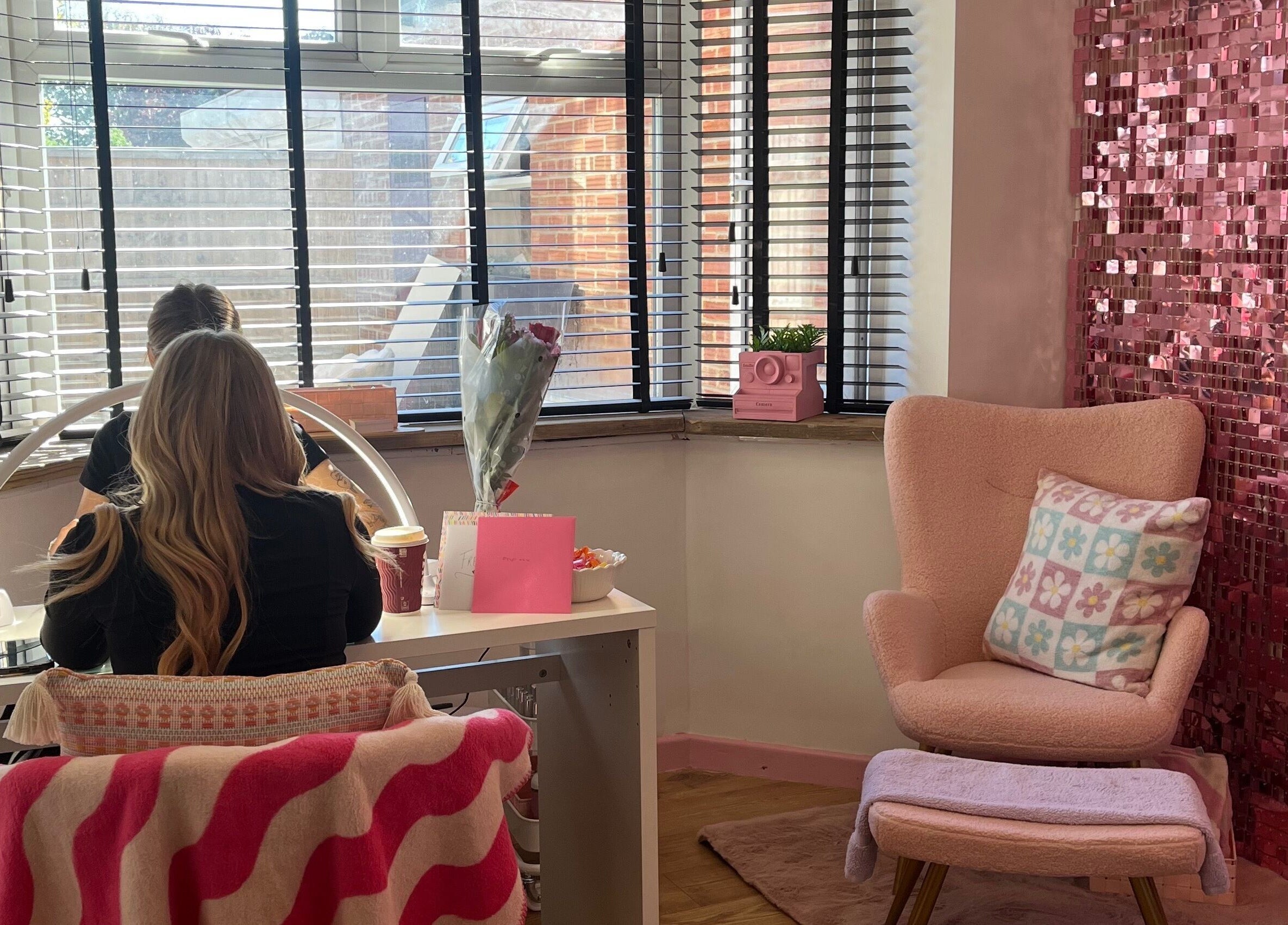 Inviting nail station at Sugar Tips, Fareham, England, GB with pink decor and comfy seating.
