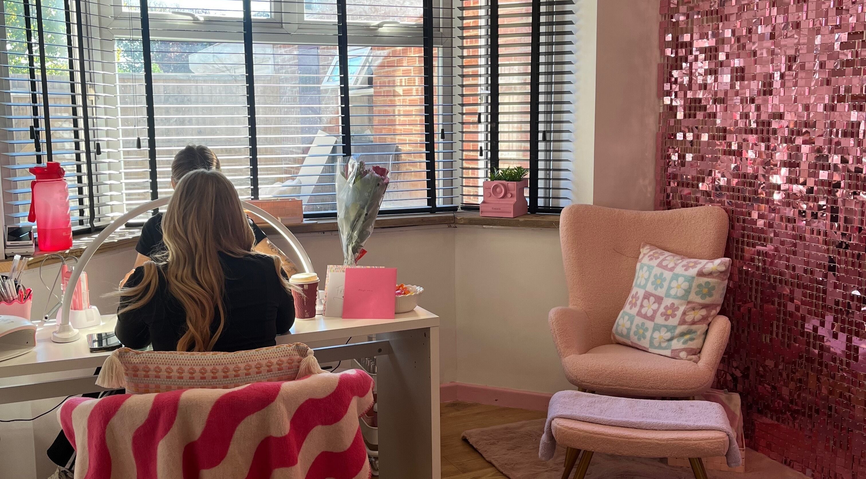 Inviting nail station at Sugar Tips, Fareham, England, GB with pink decor and comfy seating.