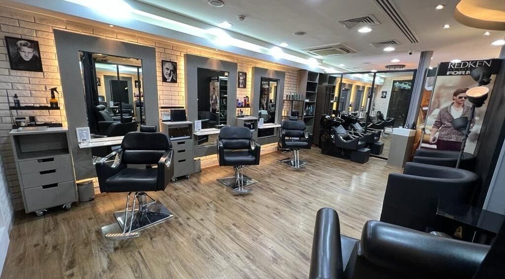 Stylish interior of Version Francaise - Barbershop Gents Salon in Dubai, Dubai, AE, featuring sleek chairs and mirrors.
